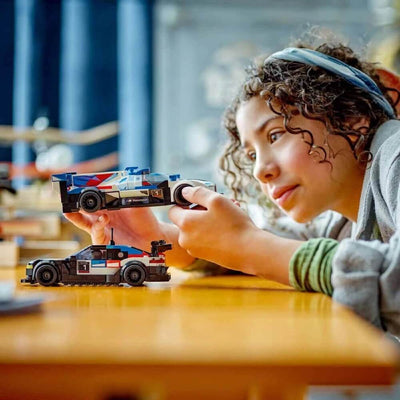 Child playing with LEGO Speed Champions BMW M4 GT3 & BMW M Hybrid V8 76922 Bir masada yarışan arabalar.