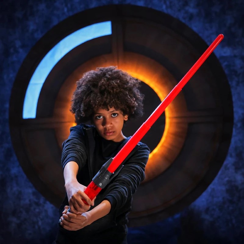 Star Wars Power The Force Işın Kılıcı Darth Maul ile poz veren genç bir çocuk, kırmızı ışın kılıcıyla etkileyici bir duruş sergiliyor.